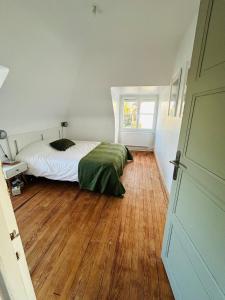 Un dormitorio con una cama y suelo de madera. en Maison à la Campagne, 