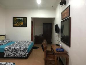 a bedroom with a bed and a television and a table at Villa Desa Permai in Sungai Besar
