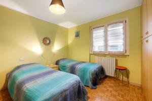 a bedroom with two beds and a window at La dimora del Lago in Colico