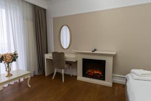 a living room with a desk and a fireplace at Crama Venetic in Prundeni
