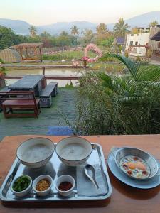 a tray with two dishes of food on a table at ม่วนใจ๋ปันสุข โฮมสเตย์แอนคาเฟ่ Muanjai punsuk homestay and cafe in Chom Thong