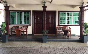 a group of chairs and tables on a porch at Villa Desa Permai in Sungai Besar