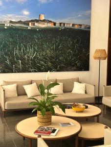 a living room with a couch and tables and a painting at Apartamentos Llobet Ibiza in Ibiza Town