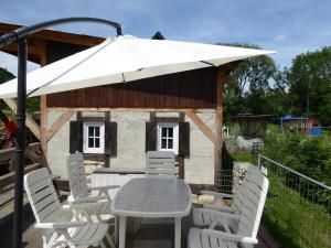 a table and chairs with an umbrella on a patio at Ferienhof Haus Sulztal in Berching