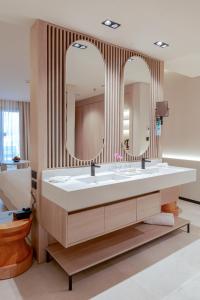 Calimera Blend Paradise في الغردقة: حمام مع حوض كبير ومرآتين