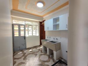 a kitchen with white cabinets and a sink at you are most welcome, feel at home in Makomboki