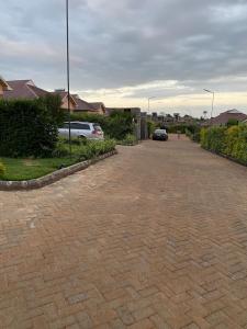 a brick driveway with cars parked in a yard at you are most welcome, feel at home in Makomboki