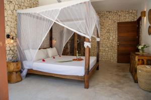 a bedroom with a bed with a canopy at Natural Park Villa Resort in Pingwe +46 photos