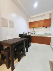 a kitchen with a wooden table and a counter top at Marinduque Apartment in Tagum