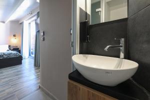 a bathroom with a white sink on a black counter at Villa Cicada Chania, Steps from the beach, Car included in Agia Marina Nea Kydonias +27 photos