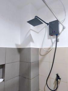 a bathroom with a shower with a laptop on the wall at Marinduque Apartment in Tagum
