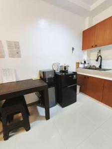 a kitchen with a black refrigerator and a sink at Marinduque Apartment in Tagum +2 photos