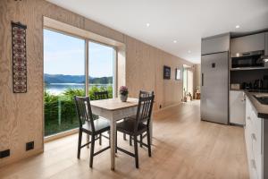 a kitchen and dining room with a table and chairs at Spectacular Fjord getaway - The Forge in Leirgulen