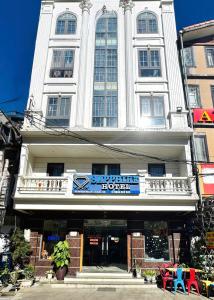 a large white building with a sign on it at Sapphire Sapa Hotel in Sapa