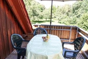 a table and chairs on a porch with an umbrella at Ferienwohnung Ferienhäuser am Brocken, 80 qm 3 Schlafzimmer in Ilsenburg +10 photos