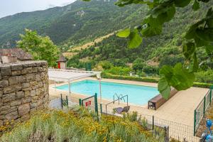 a swimming pool with a mountain in the background at Gîte Logement 4/6 personnes - Village de gites des Vignes in Les Vignes