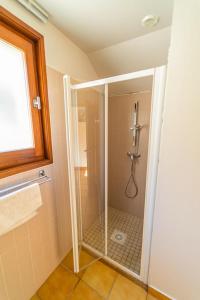a shower with a glass door in a bathroom at Gîte Logement 4/6 personnes - Village de gites des Vignes in Les Vignes +15 photos