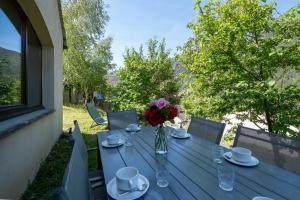 a blue table with a vase of flowers on it at Gîte Logement 4/6 personnes - Village de gites des Vignes in Les Vignes