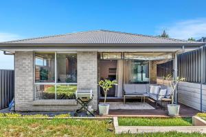 a home with a patio with a couch and a chair at Reef Retreat - Modern Beach House Sanctuary in Port Noarlunga