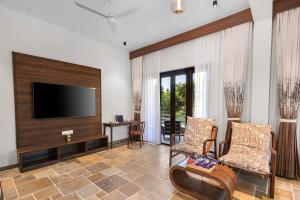 ein Wohnzimmer mit einem Flachbild-TV und 2 Stühlen in der Unterkunft Viresco by Alaya Stays in Thūr