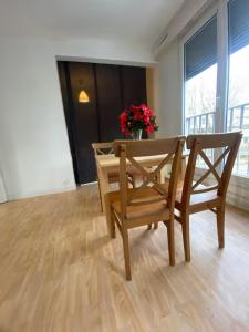 ღ Le Quai - T3 Proche Centre Ville & Gare في دويه: طاولة طعام مع كرسيين و مزهرية من الزهور