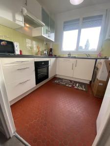 ღ Le Quai - T3 Proche Centre Ville & Gare في دويه: مطبخ مع دواليب بيضاء وارضية حمراء +17 صورة