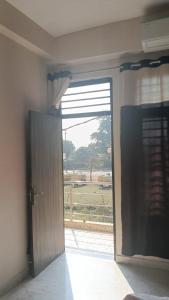 een deur naar een kamer met uitzicht op een veld bij Sanskruti home stay in Rishīkesh