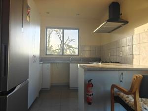 a kitchen with a sink and a window at Hearty Acres Farm Cottage in Auckland +4 photos