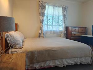 a bedroom with a large bed and a window at Hearty Acres Farm Cottage in Auckland