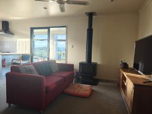 a living room with a couch and a wood stove at Hearty Acres Farm Cottage in Auckland