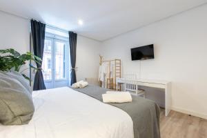 ein Schlafzimmer mit zwei Betten und einem Schreibtisch und einem Fenster in der Unterkunft Amati Boutique Coliving Madrid in Madrid + 43 Fotos
