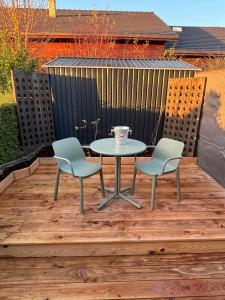Ein Tisch und zwei Stühle auf einer Holzterrasse in der Unterkunft La Barrique Champenoise - Studio and Terrasse in Tours-sur-Marne