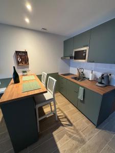 eine Küche mit Tisch und Stühlen und einer Spüle in der Unterkunft La Barrique Champenoise - Studio and Terrasse in Tours-sur-Marne