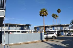 a car parked in front of a building with palm trees at Salt Air Lodge in Santa Cruz