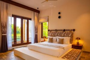 ein Schlafzimmer mit einem großen Bett und einem großen Fenster in der Unterkunft Viresco by Alaya Stays in Thūr