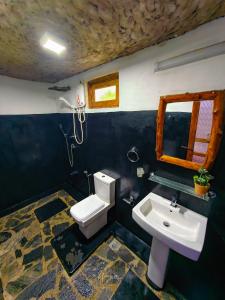 a bathroom with a white toilet and a sink at Udawalawe Safari House in Udawalawe