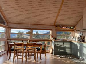 ein Esszimmer mit einem Tisch und einigen Fenstern in der Unterkunft Sveheim - cabin with an amazing view in Flå + 41 Fotos
