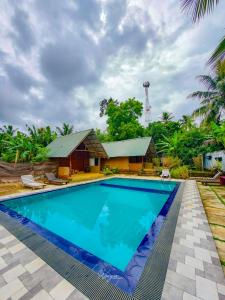 a swimming pool in front of a house at Udawalawe Safari House in Udawalawe