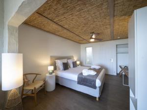 a bedroom with a bed and a table and a chair at Hotel Punta Lara Noirmoutier in La Guérinière