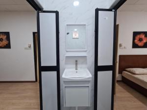 Un baño con lavabo y una cama en una habitación. en Safaira Homestay, en Alor Setar 11 fotos más