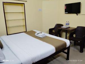 a bedroom with a bed with two chairs and a desk at Rathore Inn in Hāora +49 photos