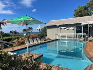 piscina con ombrellone e sedie di PrivateHolidayHome a Margate