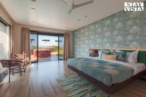 Una cama o camas en una habitación de StayVista at La Mer - Pool, Lawn & BBQ