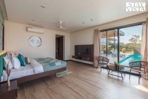 Una televisión o centro de entretenimiento en StayVista at La Mer - Pool, Lawn & BBQ 22 fotos más