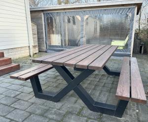 a wooden picnic table sitting on a patio at Chalet 240 in Petten