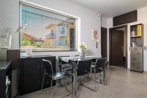 a kitchen with a table and chairs and a window at Villa Cicada Chania, Steps from the beach, Car included in Agia Marina Nea Kydonias