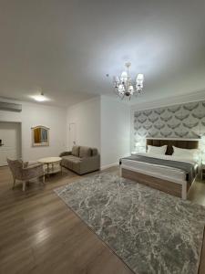 a large bedroom with a large bed and a couch at Hotel Astoria in Astana