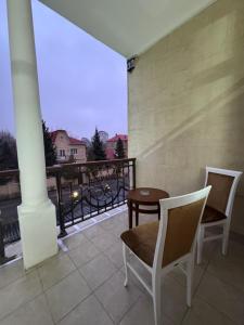 two chairs and a table on a balcony with a view at Hotel Astoria in Astana +3 photos
