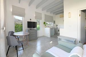 a living room with a couch and a table at The Little Vineyard Cottage in Franschhoek