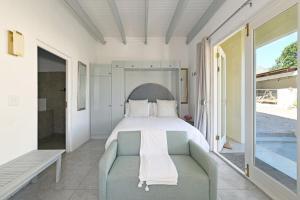 a bedroom with a bed and a couch at The Little Vineyard Cottage in Franschhoek